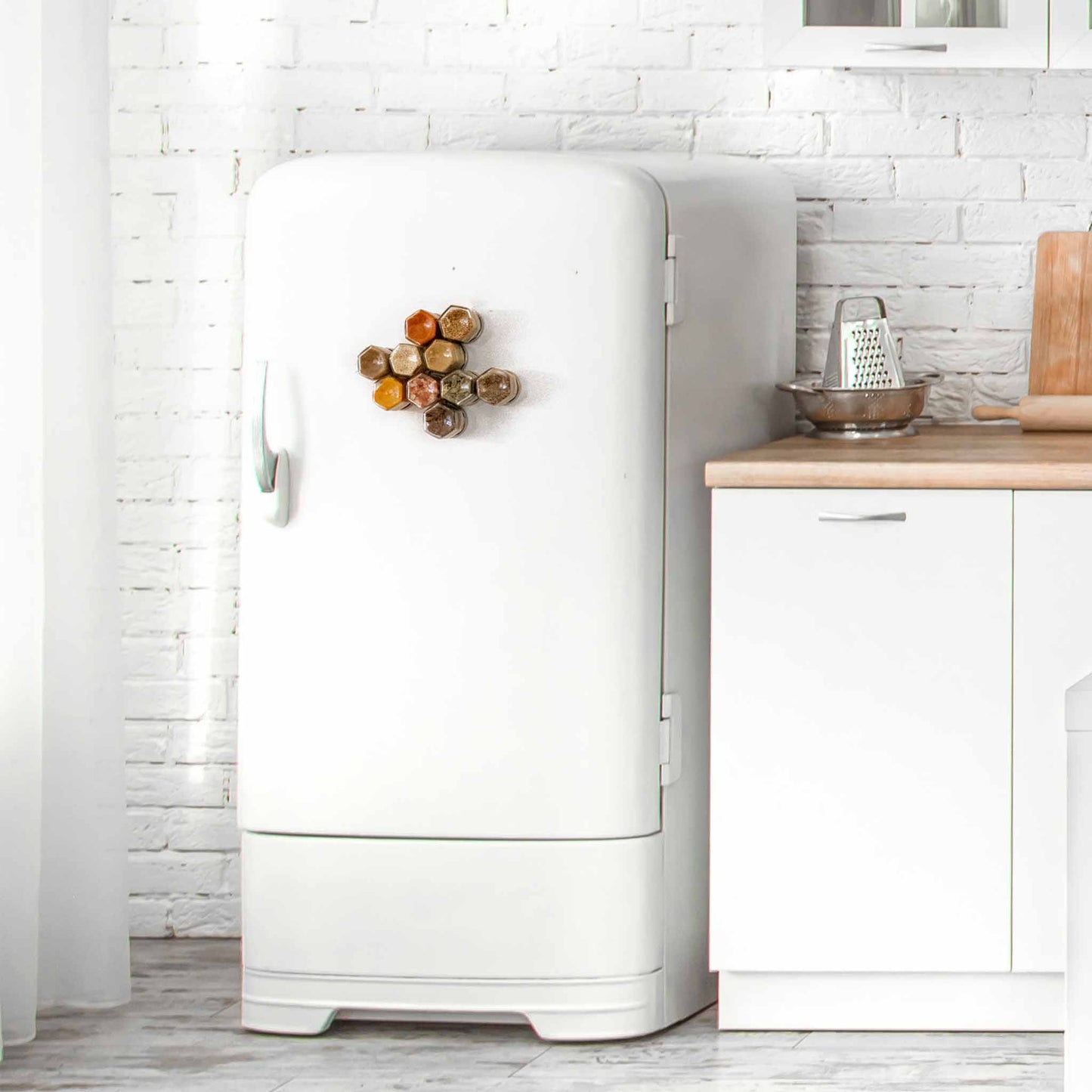 Magnetic spice jars attached to the front of a white fridge