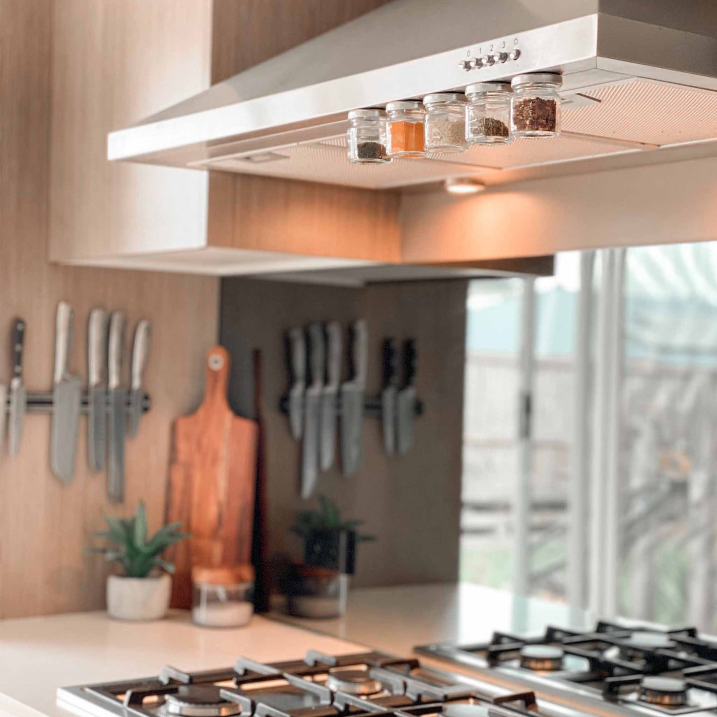 Magnetic spice jars attached to the underside of a rangehood