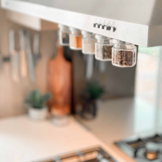 Magnetic spice jars attached to the underside of a rangehood